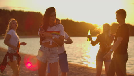 Das-Junge-Mädchen-Mit-Dunklem-Haar-Tanzt-Mit-Nackten-Hüften-Auf-Der-Open-Air-Party-Mit-Bier.-Es-Ist-Eine-Verrückte-Und-Heiße-Strandparty-Mit-Den-Besten-Freunden-In-Guter-Stimmung.